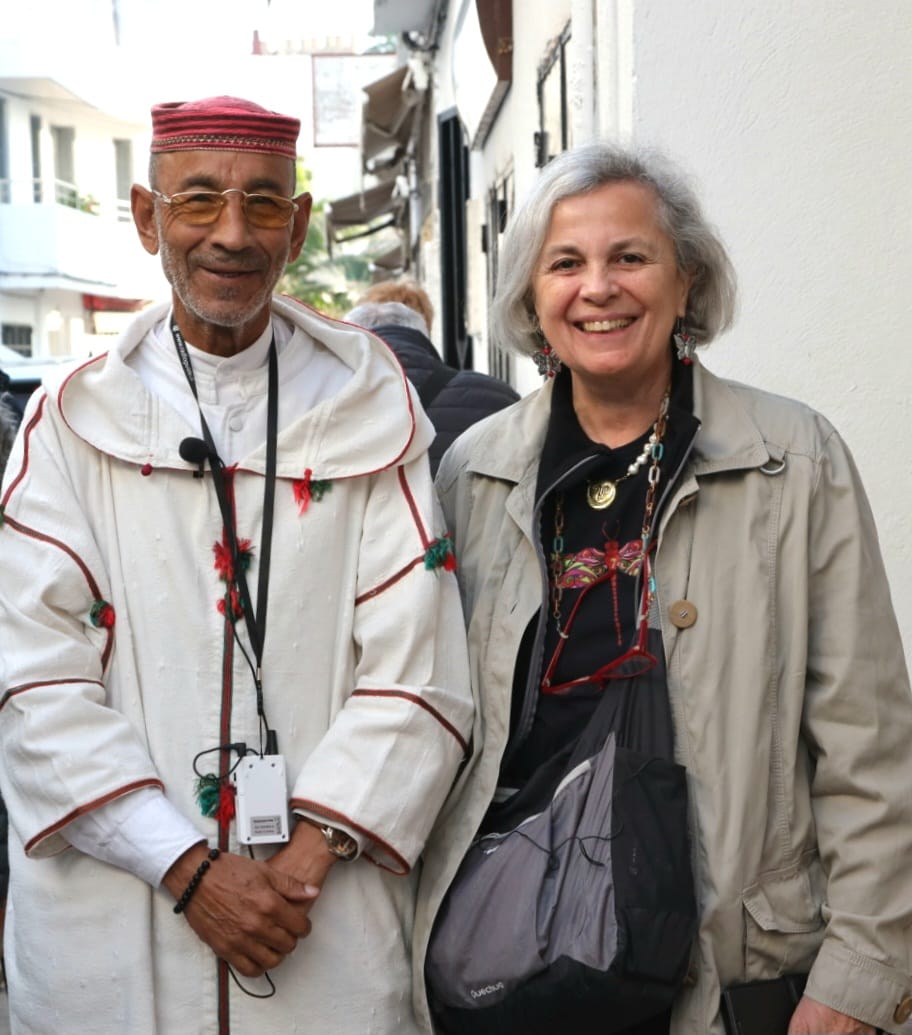 A man in traditional Chefchaouen jallaba with a tour guest in the medina