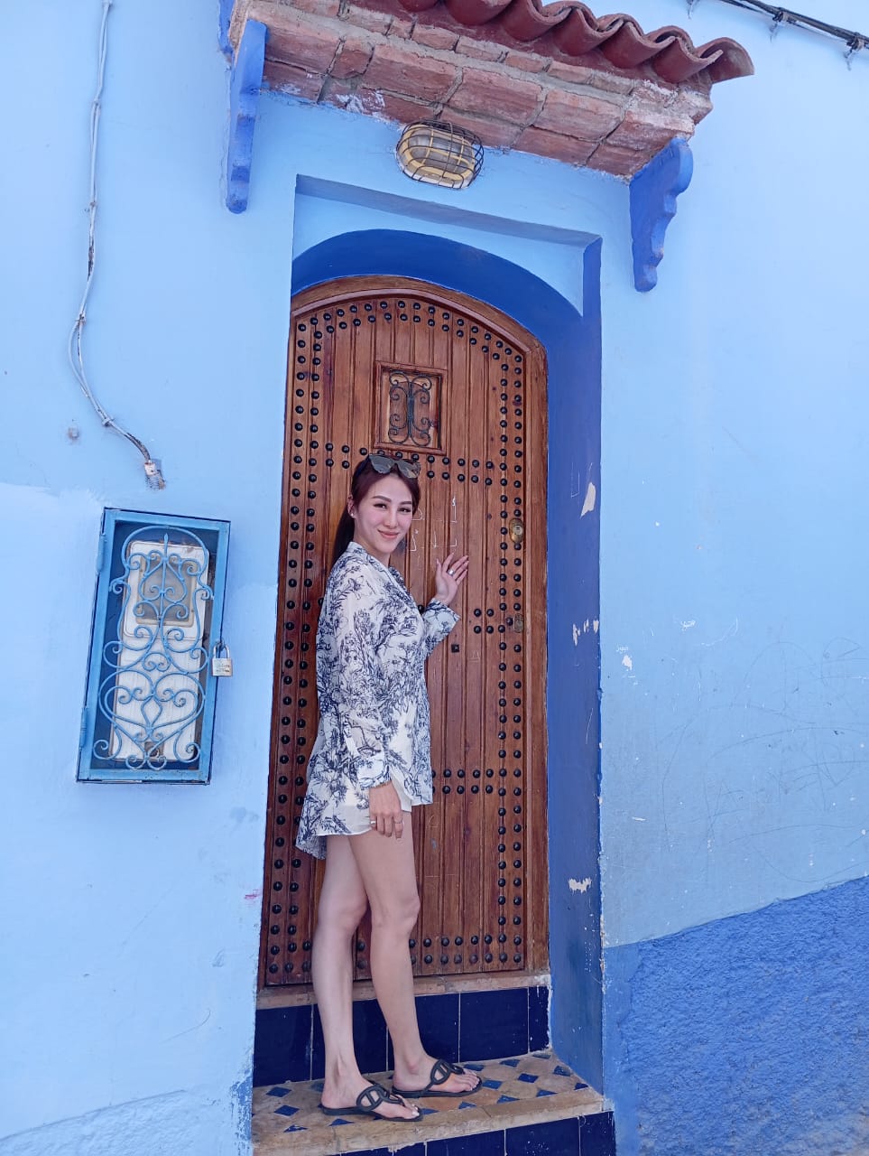 Guest posing at a beautiful blue doorway in Chefchaouen