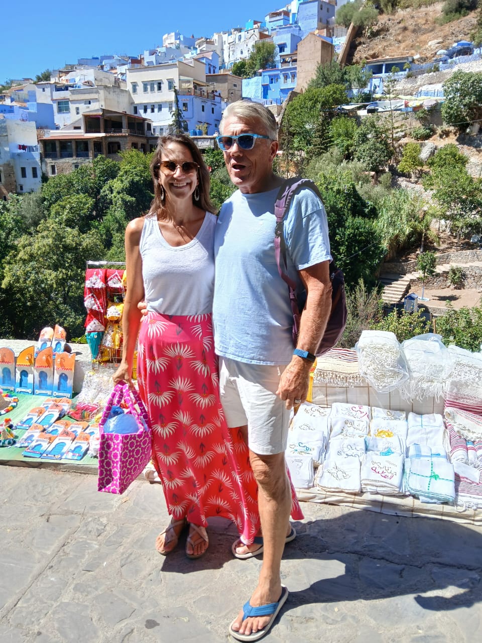 Guests at a craft market in Chefchaouen with the blue city behind them